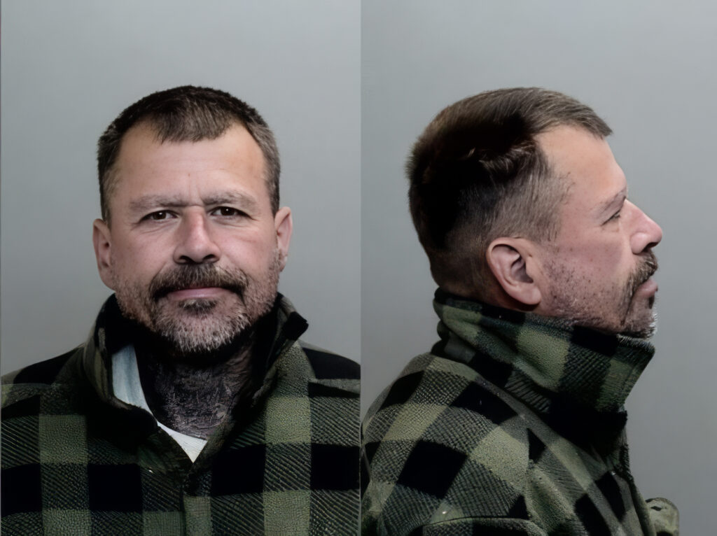 A person with short hair and a beard wears a green and black plaid jacket, shown in front and side profile against a plain background.